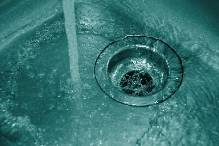 Image of water running through kitchen sink drain.