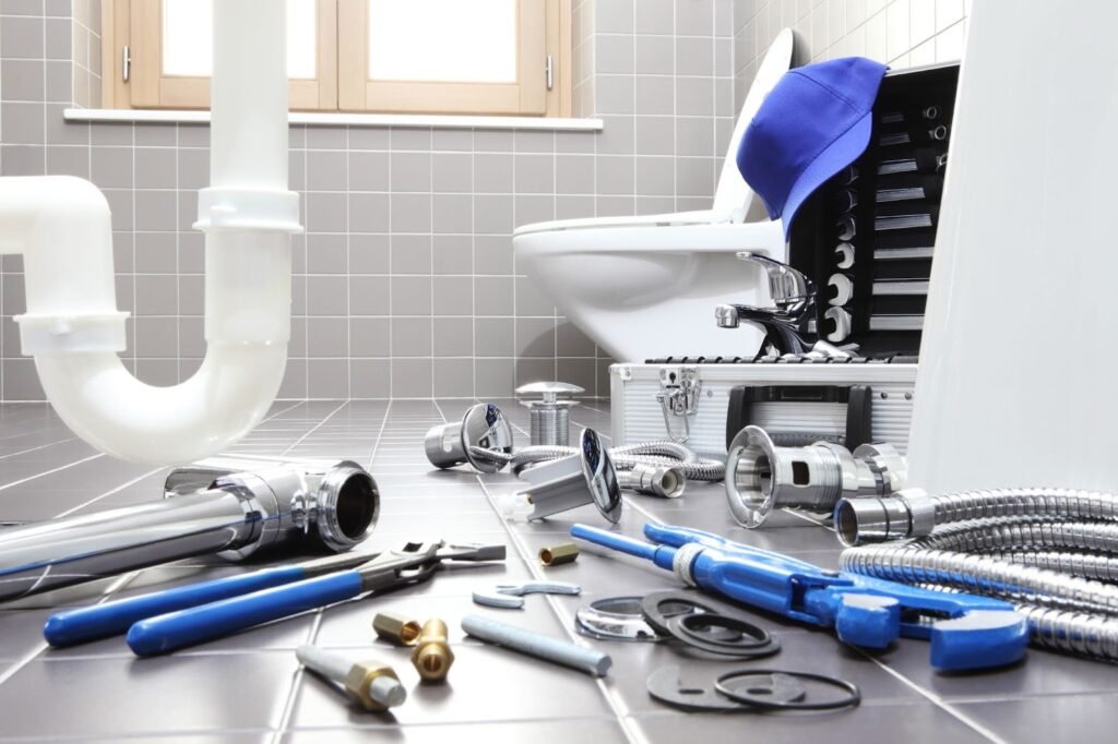 Plumbing tools and supplies for repairs, addressing issues, and managing costs scattered on the floor.