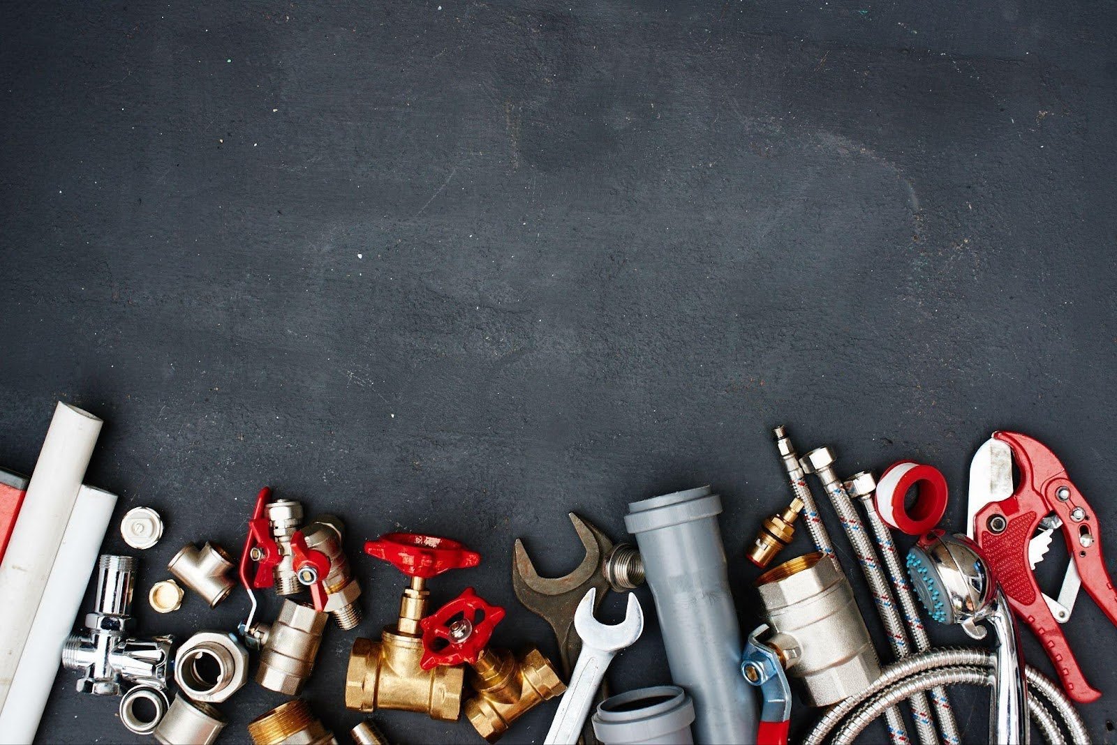 Various plumbing tools against a black background, showcasing their metallic surfaces