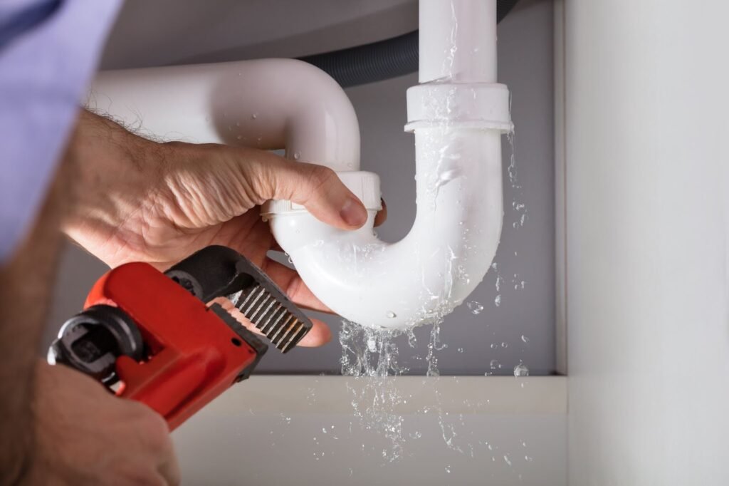 A man skillfully repairs a pipe using a tool, showcasing professional plumbing techniques in action.